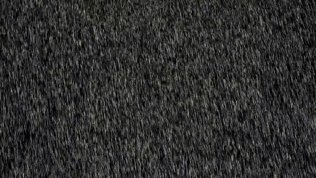 Heavy angled rain falling in front of the camera against black screen. Heavy rainstorm hitting black surface