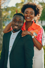 Fototapeta premium A young and stylish dark-skinned couple standing in a sunny city