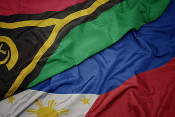 waving colorful flag of philippines and national flag of Vanuatu .