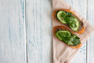 Slices of white bread with sprat paste, cucumber and parsley.  Delicious sandwiches for a snack on...