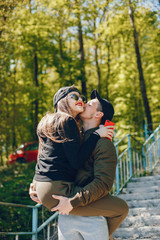 A stylish and bright love couple walks in the sunny forest