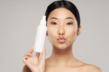 young woman applying moisturizer cream