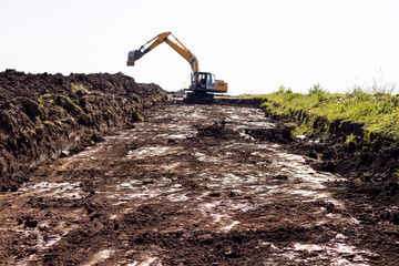 Excavator digging dirt in the field