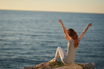 young woman doing yoga on the beach