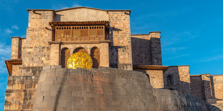 Panoramic photograph of the inca sun temple or Qorikancha in Cusco city during Inti Raymi, hence the solar disk. Famous for its inca wall stonework and Santo Domingo convent built on top, Cusco, Peru.