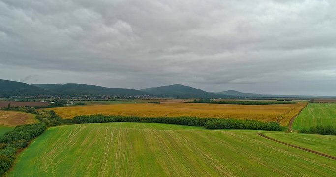 Drone view of the North Hungarian landscape of the Muzsla, part of Matra. Hills and fields of agricultural view with roads in the distance view.  Cloudy view after rain with fog in the forest.