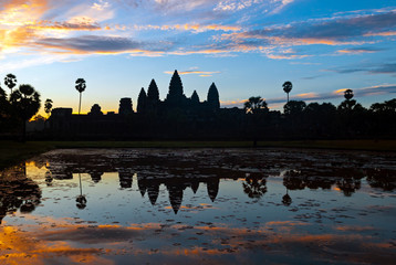 Silhouette of the Angkor Wat temple complex reflected in a man made lake at sunrise, Cambodia.