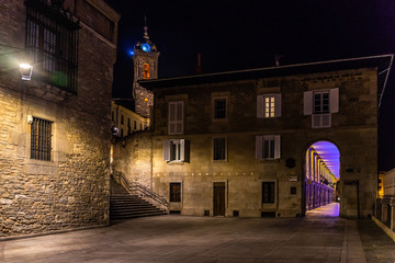 Night view of the medieval historic center of Vitoria Gasteiz with Los Arquillos building and the tower bell of Church of San Vicente Martir, Basque Country, Spain
