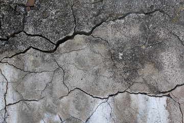 The old concrete wall is cracked. Urban texture. Old damaged wall. Destroyed wall texture, rough background.