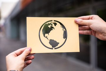 Hands Holding Paper With Cutout Planet Earth