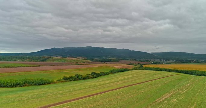Drone view of the North Hungarian landscape of the Muzsla, part of Matra. Hills and fields of agricultural view with roads in the distance view.  Cloudy view after rain with fog in the forest.
