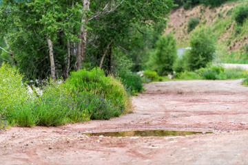 Pothole on road turnout from Highway 133 in Redstone, Colorado during summer with water in hole