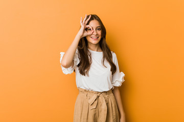 Young caucasian woman excited keeping ok gesture on eye.