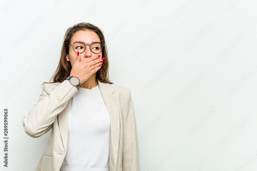 Wall mural Young european business woman thoughtful looking to a copy space covering her mouth with hand.