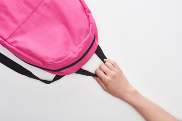 Schoolgirl holding bright pink schoolbag isolated on white