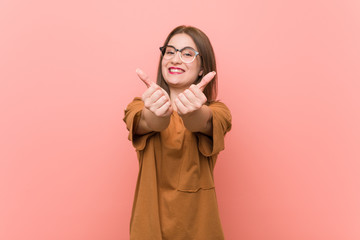 Young student woman wearing eyeglasses with thumbs ups, cheers about something, support and respect concept.