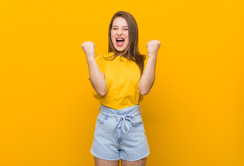 Young woman teenager wearing a yellow shirt cheering carefree and excited. Victory concept.