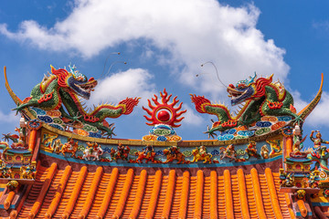 Manila, Philippines - March 5, 2019: Chinese Cemetery in Santa Cruz part of town. Closeup of colorful and extensively decorated top of main gate to temple and ceremonial hall. Blue sky, dragons.