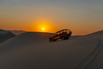 Silhouette of a buggy at sunset in the coastal Peruvian desert between Ica and Huacachina, Peru.