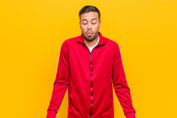Young filipino fitness man shrugs shoulders and open eyes confused.