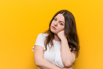 Young curvy plus size woman who feels sad and pensive, looking at copy space.