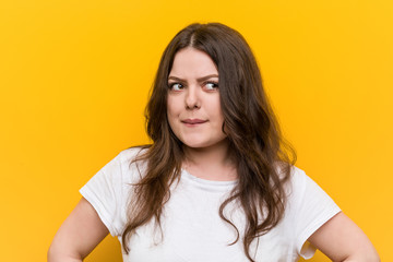 Young curvy plus size woman confused, feels doubtful and unsure.