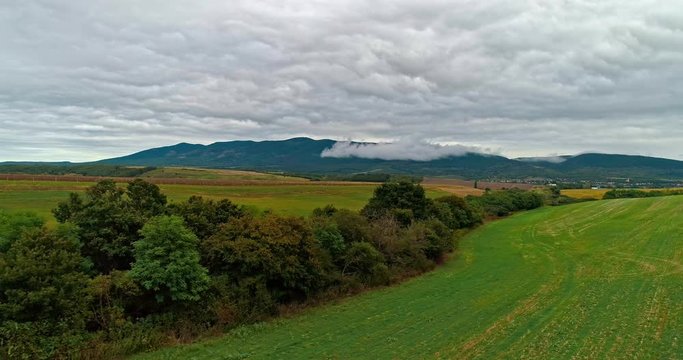 Drone view of the North Hungarian landscape of the Muzsla, part of Matra. Hills and fields of agricultural view with roads in the distance view.  Cloudy view after rain with fog in the forest.