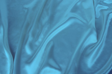 soft folds on delicate blue shiny silk, luxury concept, background for the designer, horizontal, close-up, copy space