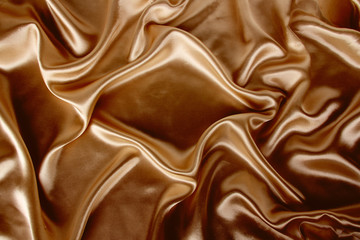 soft folds on delicate golden shiny silk, luxury concept, background for the designer, horizontal, close-up, copy space