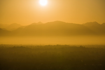 Hot smoggy summer sun rising above the San Fernando Valley and San Gabriel Mountains in Los Angeles, California.