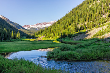 Valley view with Snowmass creek snowmelt blue color water on Snowmass Lake hike trail in Colorado in National Forest park