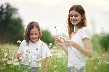 mother and daughter blowing soap bubbles in the park