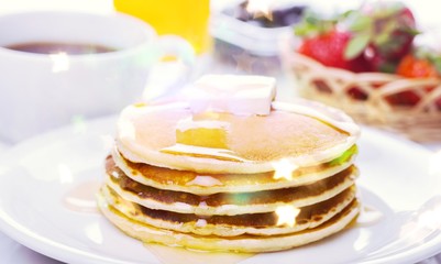 Stack of Small pancakes in syrup on background