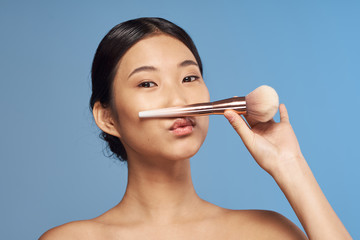 portrait of young woman with makeup brush