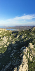 View from above, panoramic view of some stunning granite mountains illuminated by a beautiful sunset. San Pantaleo, Sardinia, Italy.