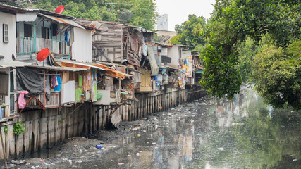 Bangkok, Thailand: slums along a smelly canal (Khlong Toei) full of mud and plastic garbage in...
