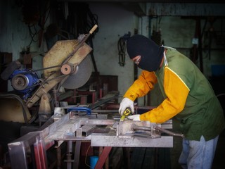 Fototapeta premium Industrial worker measure detail steel workpiece. The welders are measuring the size of the piece of steel to use the steel cutter at factory 