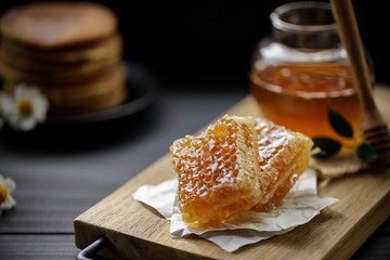 Organic honey and honeycomb on the wooden table, healthy products by organic natural ingredients...