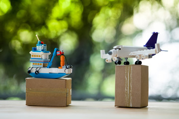 Miniature Thai ship and plane on brown box.