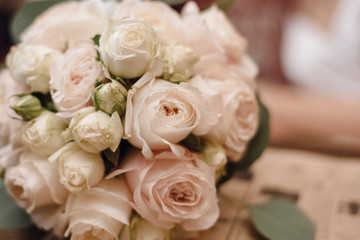 delicate wedding bouquet on a background of a young bride in a cafe. Bouquet of light roses and flowers