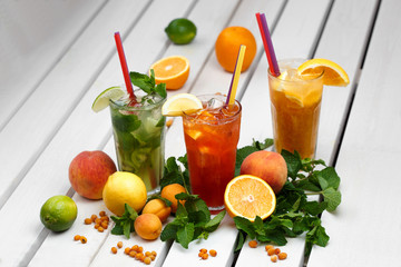 glasses with a different colored drinks with a fruits