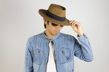 Young Asian Man in Jeans or Denim Jacket Touch Hat Brim in 45 Degree Pose