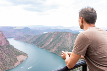 Fototapeta na wymiar Man looking at Canyon Rim Campground in Flaming Gorge Utah National Park of Green River high angle aerial overlook view in evening