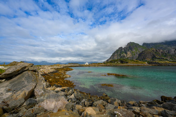 Fototapeta na wymiar Viewpoint close to Henningsvaer, mountains, sea and rocks during the cloudy season in summer at the Lofoten Islands in Henningsvær, northern Norway