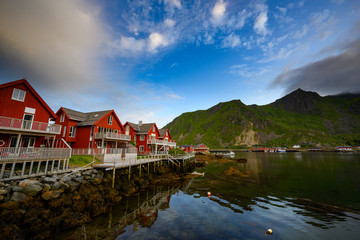 Beautiful waterfront house reflecting the water Evening and twilight sky at ballstad city, lofoten island in northern Norway. Rorbuer is the traditional home of Norwegian fishermen.