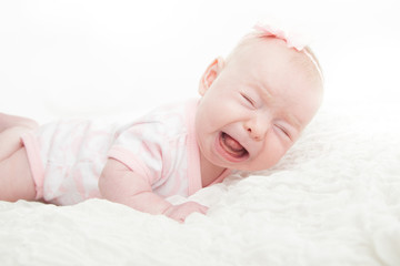 crying or screaming baby while lying on their tummy or stomach