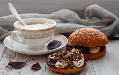 sandwich with chocolate-milk paste, bananas and nuts with coffee on a white table