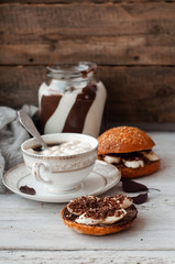 sandwich with chocolate-milk paste, bananas and nuts with coffee on a white table