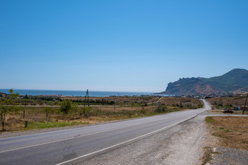 Asphalt road leading to the sea and to the village of Koktebel, Crimea.