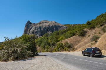 A winding asphalt road on the Black Sea coast of Crimea on a summer day.